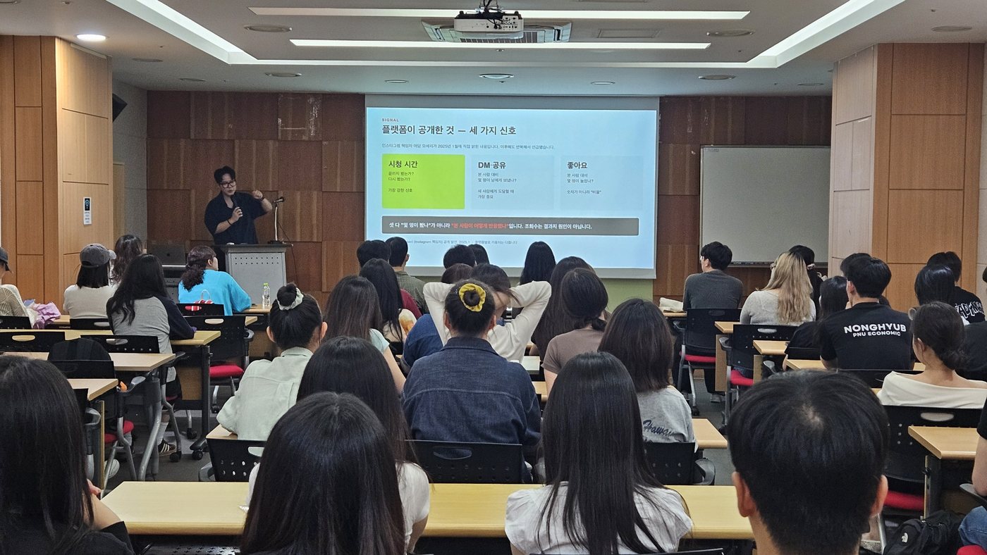 강의실 뒤편에서 촬영한 전경. 대학생 69명이 스크린을 보고 있다