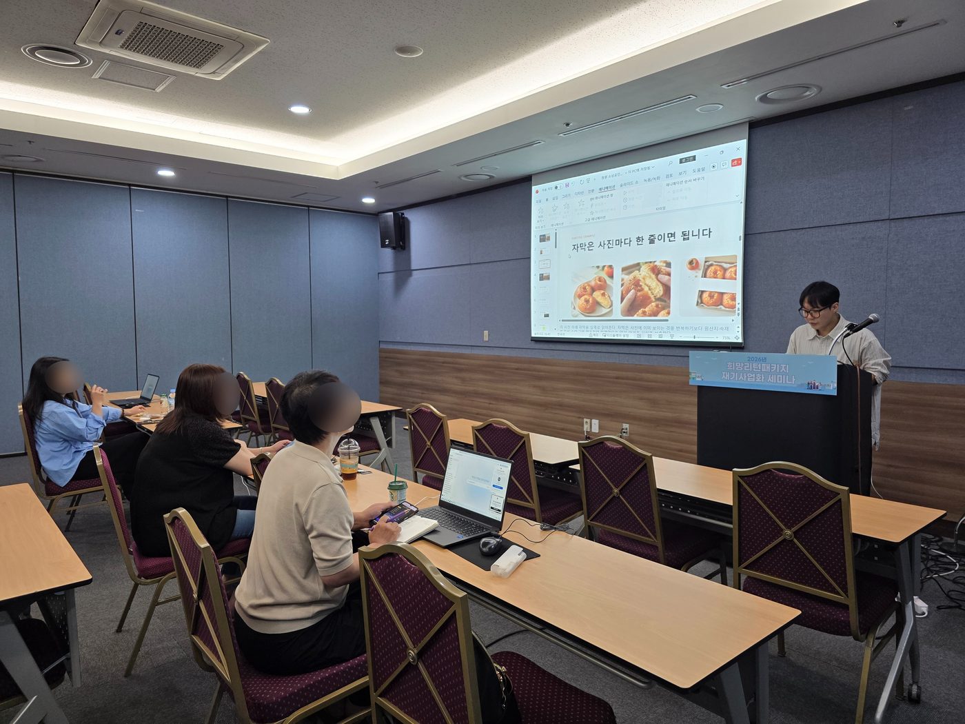 자막은 사진마다 한 줄이면 된다는 예시 슬라이드를 띄워 놓고 설명하는 장면. 슬라이드에는 상품 사진 세 장이 나란히 놓여 있다