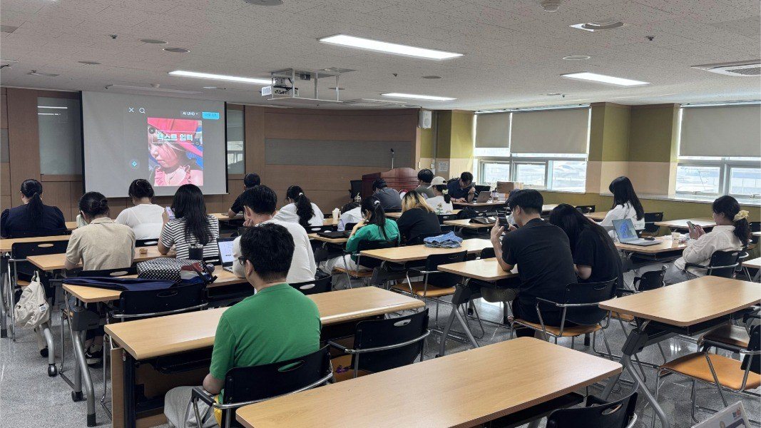 화면에 텍스트를 얹는 편집 과정을 시연하는 장면. 수강생들이 각자 스마트폰으로 따라 하고 있다