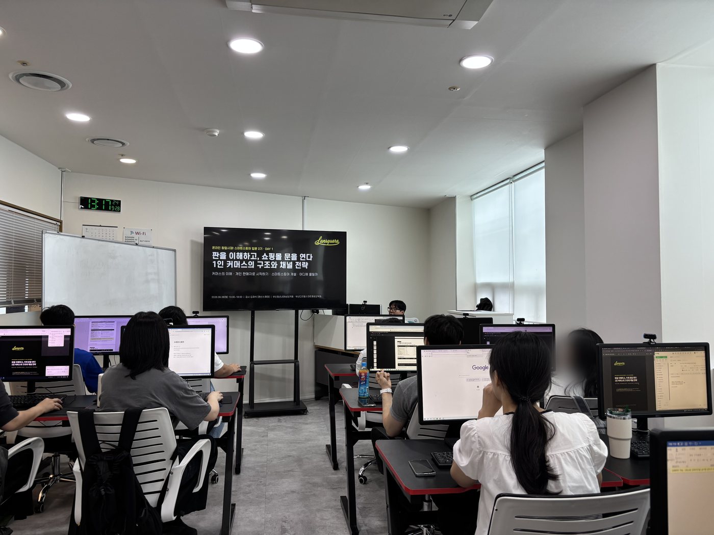 스마트스토어 입문 2기 첫날, 화면에 '판을 이해하고, 쇼핑몰 문을 연다 1인 커머스의 구조와 채널 전략' 표지를 띄운 강의실